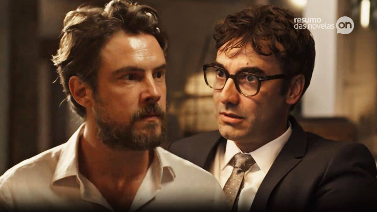 José Mendes a esquerda com olhar sério, e Márcio a direita de paletó, gravata cinza e de óculos, a direita, em cena da novela Mar do Sertão