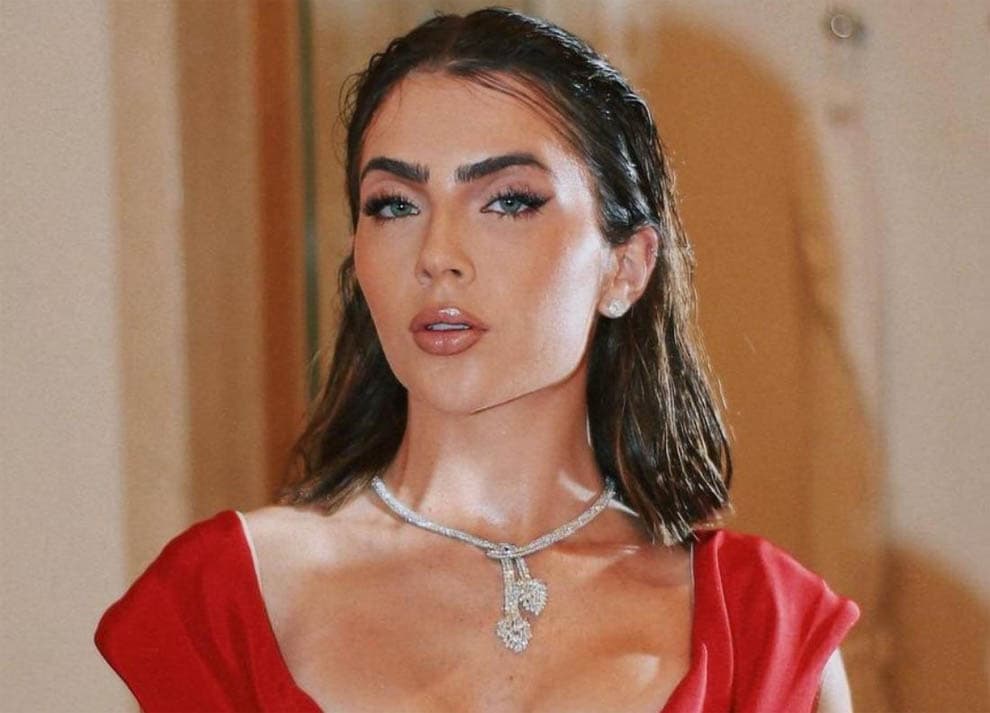 Jade Picon, que interpreta Chiara em Travessia, com um vestido vermelho e colar de diamantes, com olhar de poder.