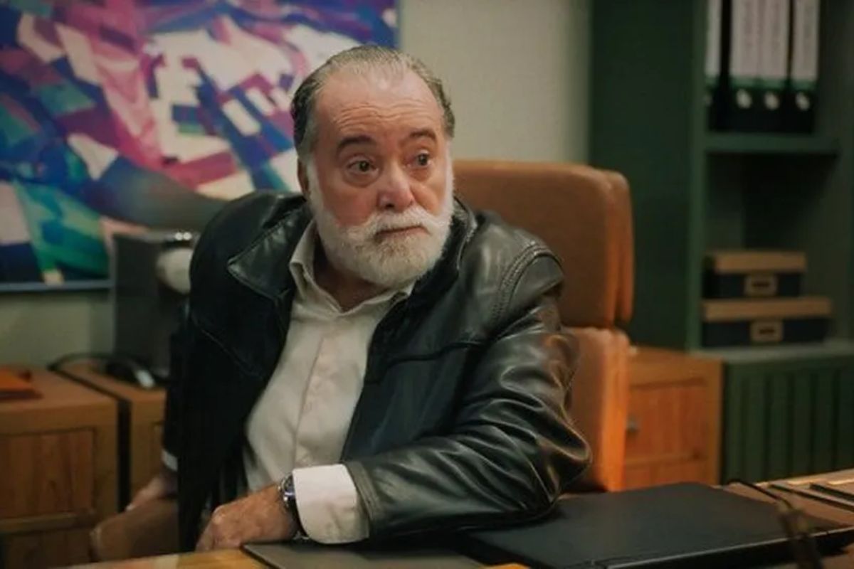 Antônio, personagem de Tony Ramos, sentado e com um dos braços apoiado na mesa em cena de Terra e Paixão.