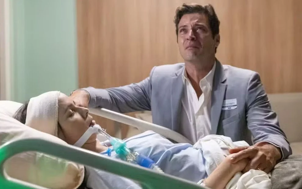 Lucinda aparece entubada em um leito de hospital, com Marino chorando diante dela, em Terra e Paixão.